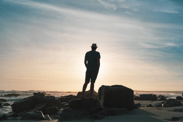 istock person at sunset on the beach 1336319551