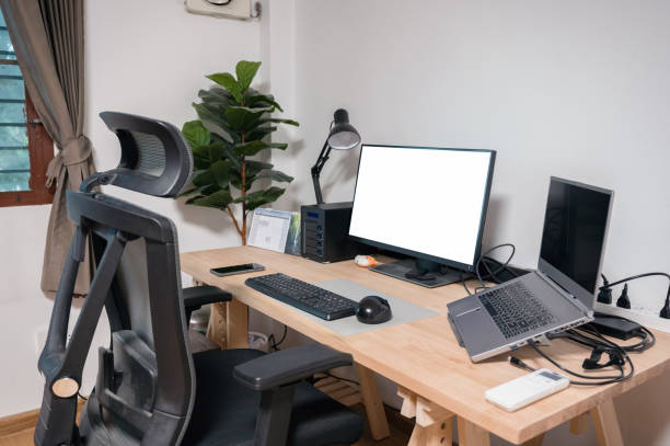 istock Wooden desk with laptop, display, mouse, lamp, ergonomic chair and artificial tree in workplace on bedroom 1336323097