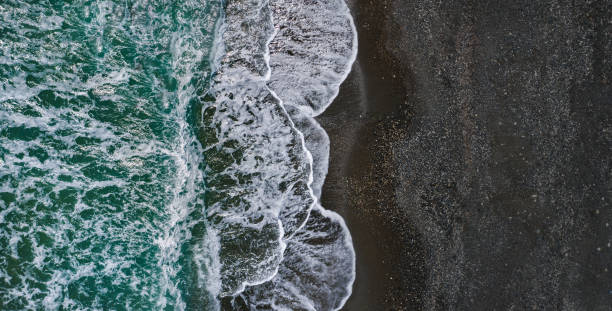 istock Sea shore with dramatic texture of breaking waves and black sand, drone view 1336323198