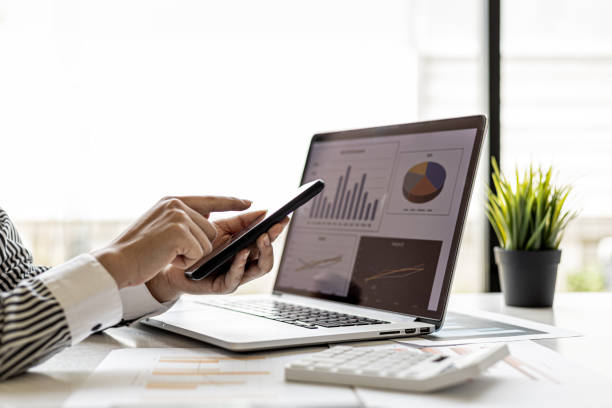 istock A businesswoman is holding a smartphone and using it, she is using a smartphone to send text messages to a company partner about financial statements. Concept of using technology in communication. 1336326713