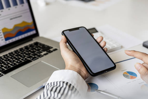 istock A businesswoman is holding a smartphone and using it, she is using a smartphone to send text messages to a company partner about financial statements. Concept of using technology in communication. 1336326816