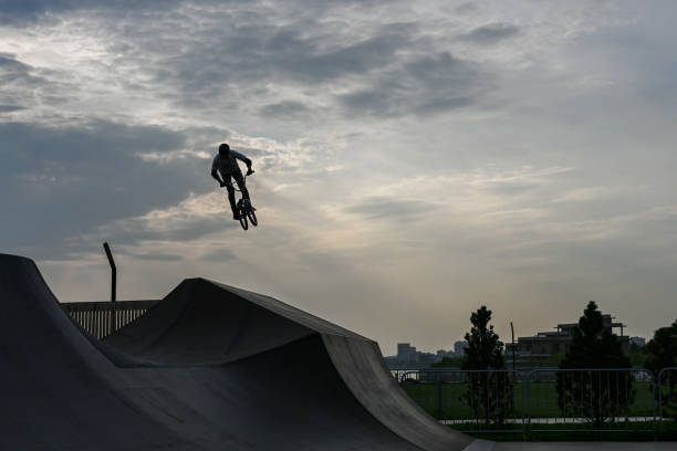 el ciclista cabalga en un parque extremo. el doble. el skate park, rollerdrome, rampas de cuarto y medio tubo. deporte extremo, cultura urbana juvenil para la actividad callejera adolescente. - bmx cycling sport teenagers only teenager fotografías e imágenes de stock