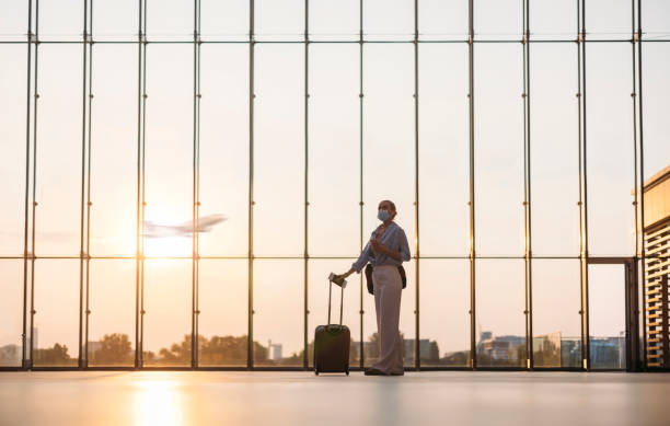 donna d'affari in piedi con la valigia all'aeroporto - airport airplane travel airport lounge foto e immagini stock