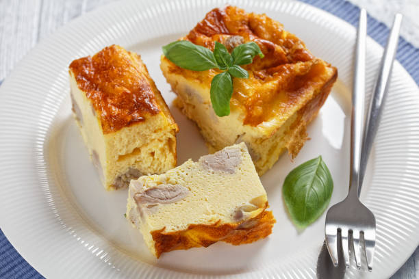 istock chicken breast and egg casserole, chicken meat omelette on a white plate with silver fork and knife on a wooden table, horizontal view from above 1336331522