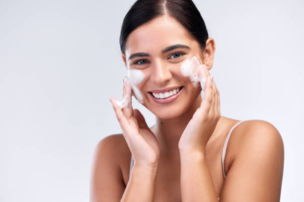 tiro de estúdio de uma bela jovem mulher lavando o rosto - creme de limpeza facial - fotografias e filmes do acervo