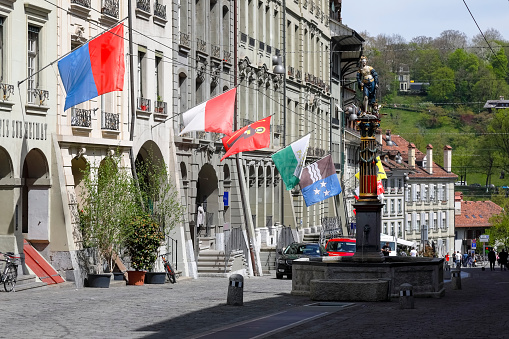 Bern, Switzerland - April 23, 2019: The sculpture on the top of the fountain shows a woman who symbolizes justice and is visible in the surroundings of historical buildings. The City of Bern is one of the countless great places in Switzerland and it is the political centre of this Country. Numerous museums, a wide cultural offer, a variety of tourist attractions makes it a travel destination for tourists from all over the world.