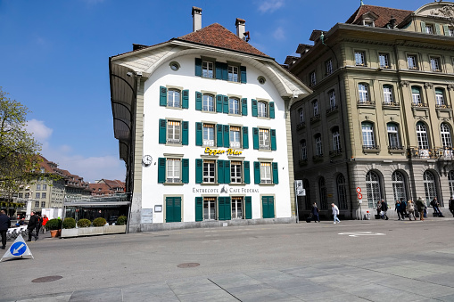 Bern, Switzerland - April 15, 2019: The view of the city centre shows stylish tenement houses, many of which have windows equipped with shutters. The City of Bern is one of the countless great places in Switzerland and it is the political centre of this Country. Numerous museums, a wide cultural offer, a variety of tourist attractions makes it a travel destination for tourists from all over the world.