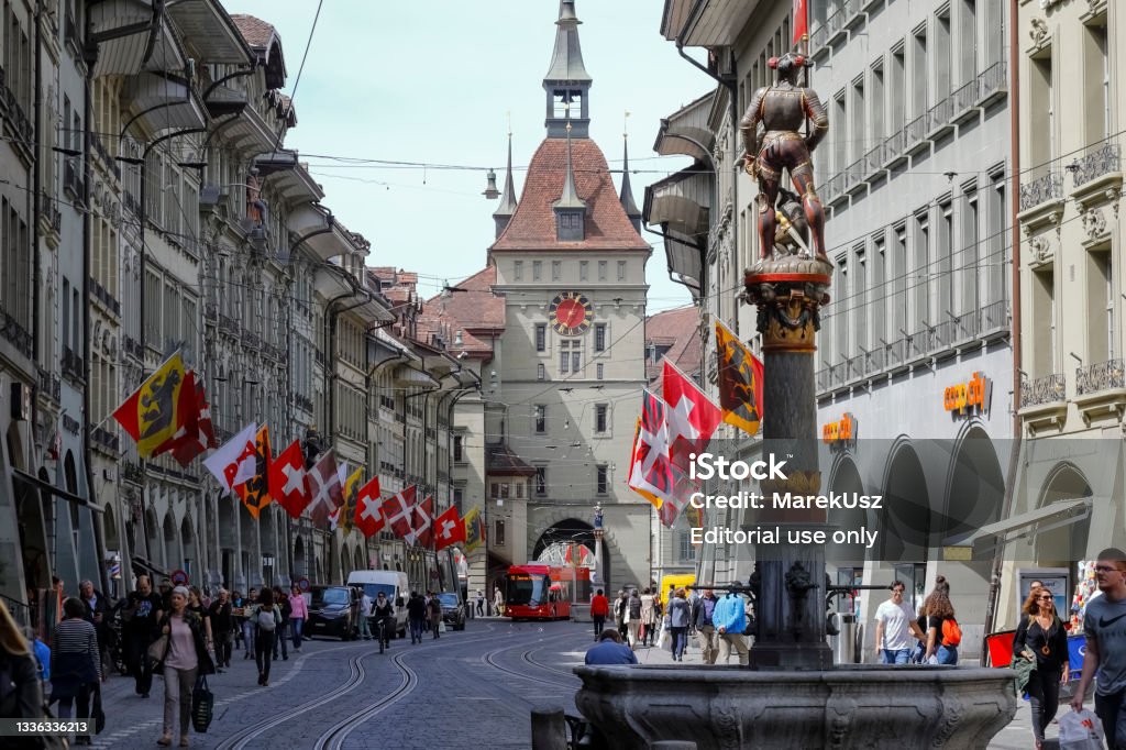 The facade of the Clock Tower in Bern Bern, Switzerland - April 23, 2019: The facade of the Clock Tower and there is a fountain, which are located in the Old Town. These are the most recognized monuments of the city. The City of Bern is one of the countless great places in Switzerland and it is the political centre of this Country. Numerous museums, a wide cultural offer, a variety of tourist attractions makes it a travel destination for tourists from all over the world. Bern Stock Photo