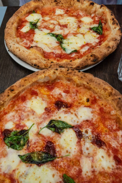istock Two freshly baked napolitano pizzas on a table.. 1336340086