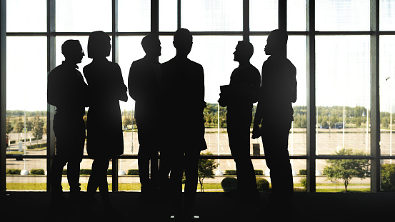 Full length portrait of confident business team standing against white background
