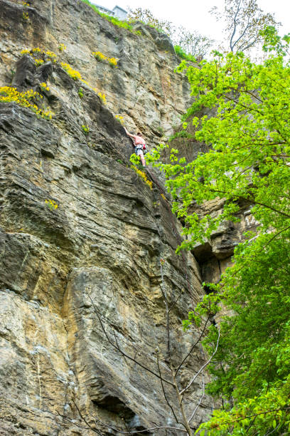 istock Girl on a steep rock climbs up 1336341704