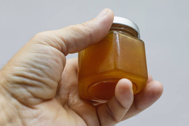 istock Glass jar with honey in hand close-up 1336341774