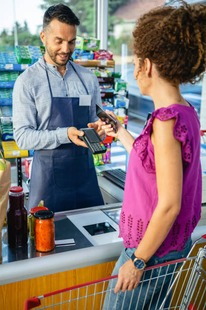istock Female customer paying for groceries with smartphone 1336342222