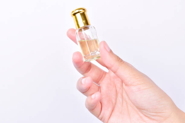 istock Attar bottle in hand isolated on white background, essential oil 1336344523