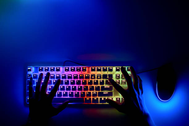 istock Hands on the keyboard in the first person. A hacker is sitting at a computer in a dark room. The concept of cybercrime. Keyboard and mouse with RGB light and human hands. 1336345718
