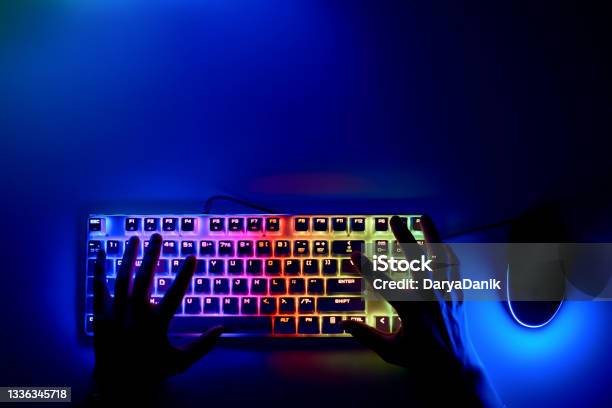 Hands On The Keyboard In The First Person A Hacker Is Sitting At A Computer In A Dark Room The Concept Of Cybercrime Keyboard And Mouse With Rgb Light And Human Hands Stock Photo - Download Image Now