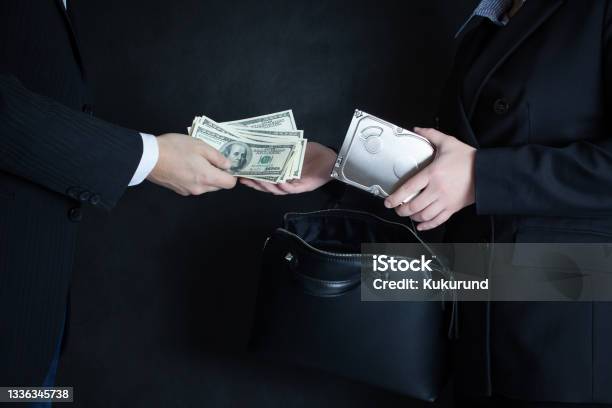 The Scene Of The Crime Selling Confidential Information On The Hard Drive Of Competitors Or Officials For The Wad Of Bills In Us Dollars Black Background Stock Photo - Download Image Now