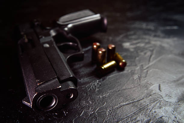 istock Pistol with cartridges on black concrete table. 1336345996