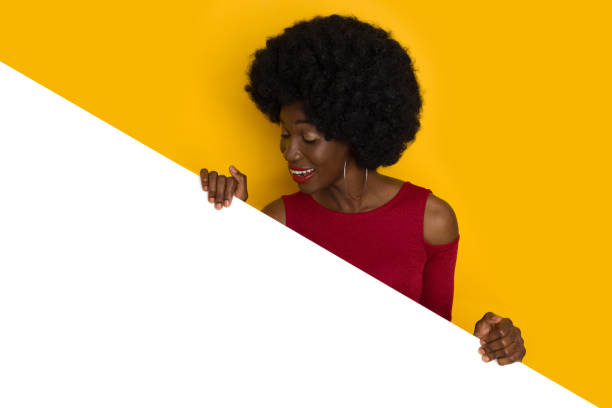 Black Young Woman Behind White Banner Looking Down stock photo