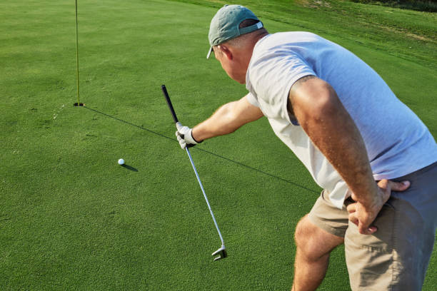 istock Professional golfer aims at a hole using golf club while playing golf or competition 1336347117