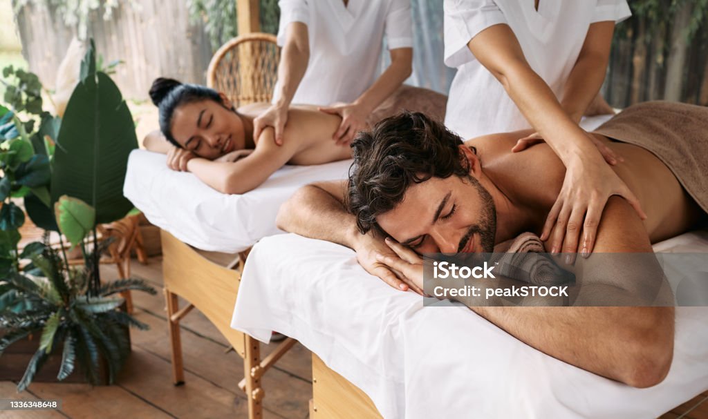 Couple massage at spa resort. Beautiful couple getting a back massage outdoor, romantic weekend and relax Spa Stock Photo
