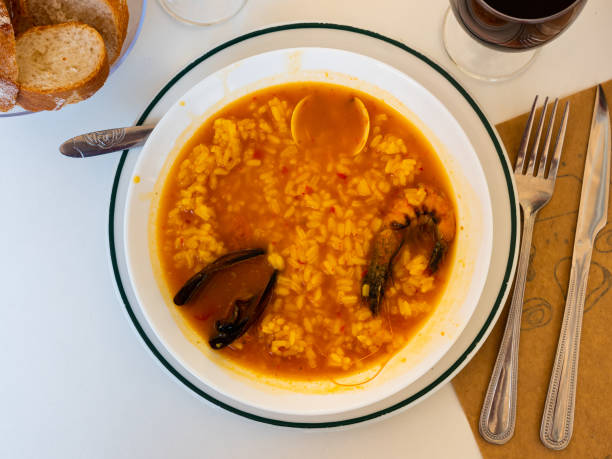 Brothy seafood rice Arroz caldoso de marisco in white plate with glass of wine bree stock pictures, royalty-free photos & images