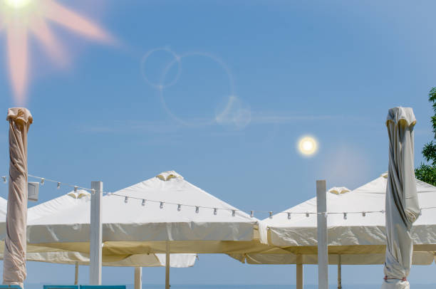 istock Light white summer cafe with umbrellas, Garland and blue sky 1336354624