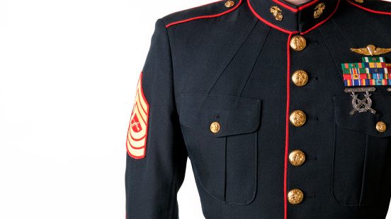 A Marine stands in his dress blue uniform