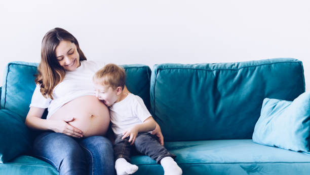 istock Cute small boy talking with his pregnant mother 1336356061