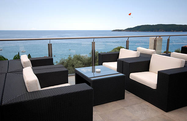 Terrace lounge with rattan armchairs and seaview in a luxury resort .