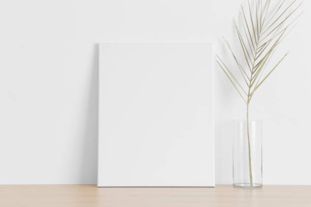 istock White canvas mockup with a palm leaf on the wooden table. 1336358438