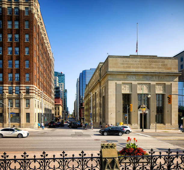 Ottawa O'Connor Street view on a hot Summer afternoon, with lots of pedestrian tourists and some cars populating the action and the bank of Montreal building to the right.