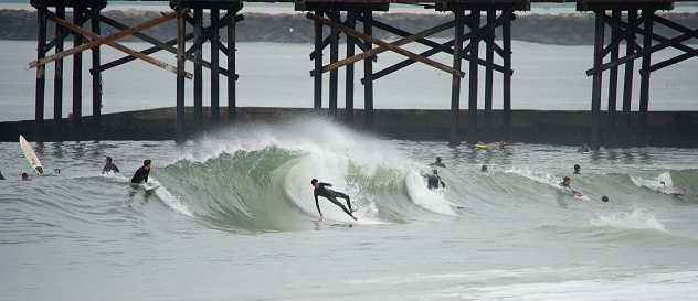 A surfer gets thrown down the face of the wave as backwash strikes the young man off his board and into the gallows during a run of winter swell in Orange County, California.