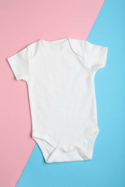 istock Child's bodysuit on light blue and pink background, top view 1336363140