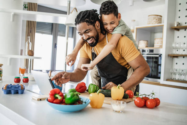 istock Young boy having fun with his father while preparing a healthy meal 1336365497