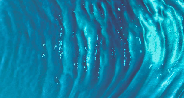 istock Water waves top view with bubbles on a turquoise background. Water surface texture 1336368632