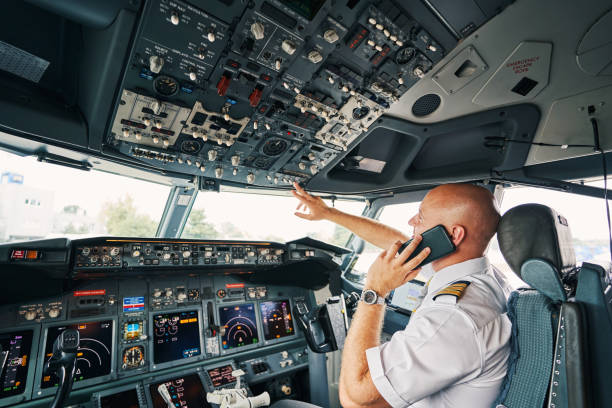 istock Airline captain flipping the switch on the overhead control panel 1336369851