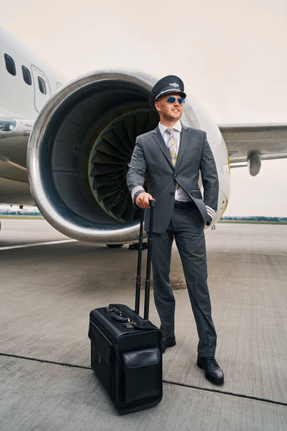 istock Smiling airman with his baggage at the aerodrome 1336369901