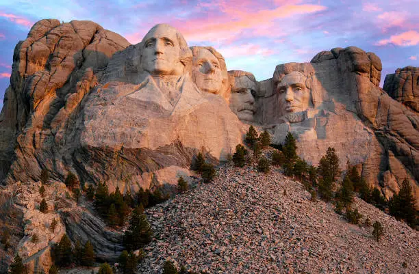 Photo of Mount Rushmore morning as the sun begins to light up the mountain range.