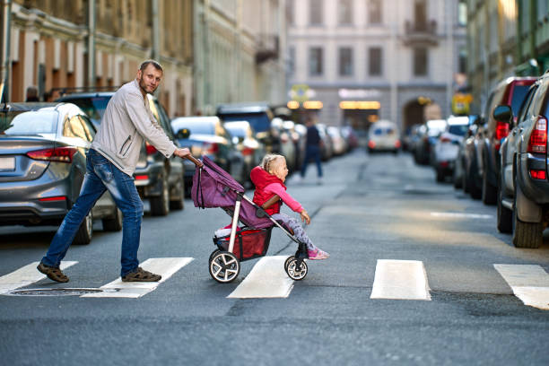 istock Father drives child in  perambulator along  pedestrian crossing. 1336372953