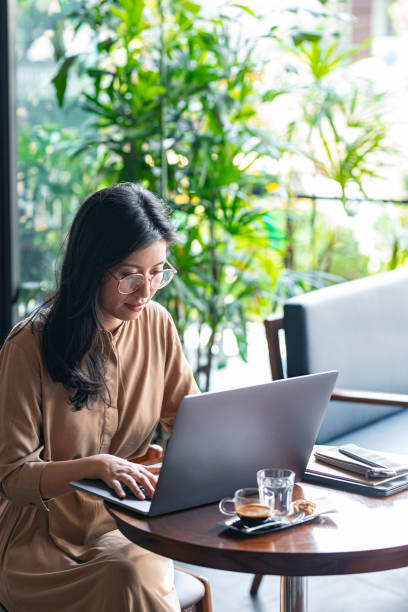 istock Asian Woman/College Student Using a Laptop Computer to Study Remotely at a Cafe 1336373162
