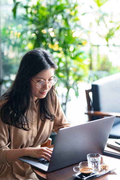 istock Asian Woman/College Student Using a Laptop Computer to Study Remotely at a Cafe 1336373168