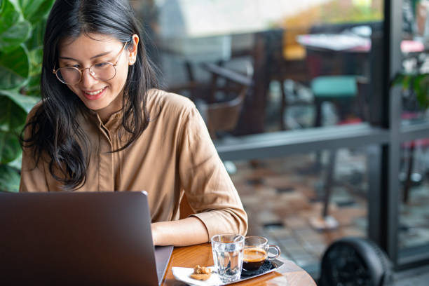 istock Asian Woman/College Student Using a Laptop Computer to Study Remotely at a Cafe 1336373171