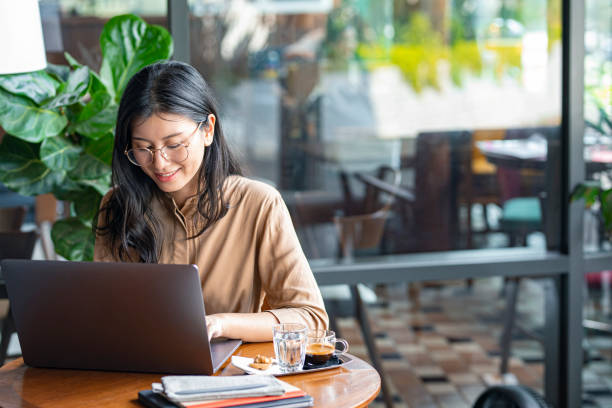 istock Asian Woman/College Student Using a Laptop Computer to Study Remotely at a Cafe 1336373174