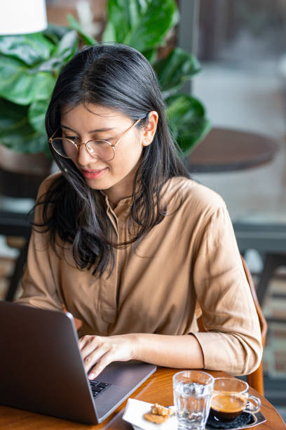 istock Asian Woman/College Student Using a Laptop Computer to Study Remotely at a Cafe 1336373177