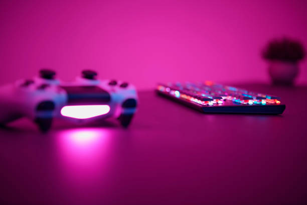 istock Purple toned photo of gaming controller and keyboard laying on table. Low angle view. 1336373800