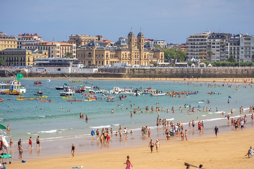 Bathers on San Lorenzo beach during low tide in the city of Gijón. Principality of Asturias. Spain. August 1, 2023.