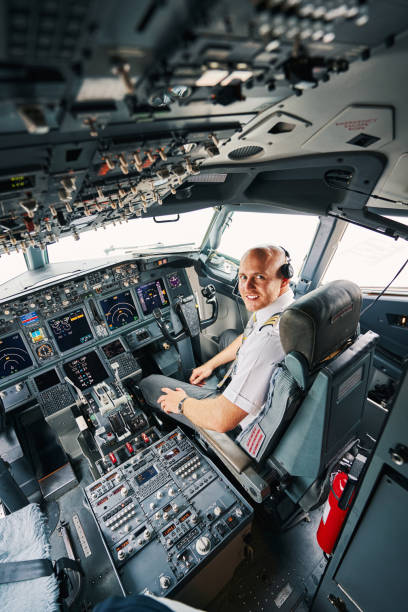 istock Pleased young pilot sitting in the cockpit before the take-off 1336374921