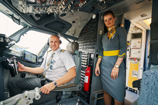 istock Pleased pilot and a lovely stewardess posing for the camera 1336374922