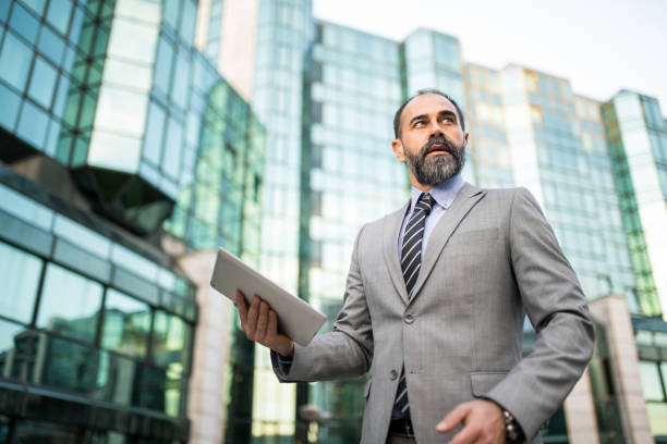 istock Mid adult businessman using digital tablet at financial district. 1336375929
